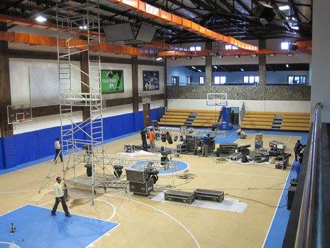 View of the main gym floor. Workers are setting up the light and sound system for the gym dedication party (for the whole school) to be held on Friday evening.